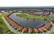 Panoramic aerial view of a charming community with houses along a lake and a golf course at 23415 Waverly Cir, Venice, FL 34293