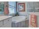 Bathroom featuring a soaking tub, tiled surround, and corner glass shower at 23415 Waverly Cir, Venice, FL 34293