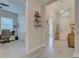 Hallway with tile flooring leads to a home office and entryway, offering a seamless transition between spaces at 23415 Waverly Cir, Venice, FL 34293