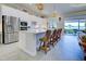 Bright kitchen with white cabinets, stainless steel appliances, and a large island with counter seating at 23415 Waverly Cir, Venice, FL 34293