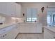 Charming kitchen with white cabinets, modern appliances, and a view of the water at 23415 Waverly Cir, Venice, FL 34293