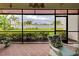 Screened-in patio with brick floors, comfortable seating and a view of the lake and palm trees at 23415 Waverly Cir, Venice, FL 34293