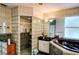 Spacious bathroom featuring a glass block shower, bathtub, modern fixtures, and ample counter space at 23495 Altman Ave, Punta Gorda, FL 33980