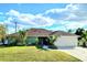 Charming single-story home with a lush front yard and a spacious two-car garage at 23495 Altman Ave, Punta Gorda, FL 33980