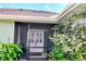 Inviting front screened entrance featuring double doors, lush plants, and seating, creating a welcoming first impression at 23495 Altman Ave, Punta Gorda, FL 33980