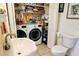 Functional laundry room with washer, dryer, sink, and storage shelving at 23495 Altman Ave, Punta Gorda, FL 33980