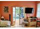 Cozy living room with tiled floors, pool view, and modern entertainment setup with mounted TV at 23495 Altman Ave, Punta Gorda, FL 33980