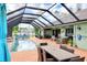 Inviting pool area featuring a screened enclosure, brick pavers, comfortable seating, and lush landscaping at 23495 Altman Ave, Punta Gorda, FL 33980