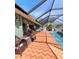 Relaxing pool area featuring a screened lanai, brick pavers, and ample seating, creating an inviting outdoor living space at 23495 Altman Ave, Punta Gorda, FL 33980