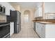 Well-lit kitchen showcasing stainless steel appliances, white cabinetry, and tile flooring at 2487 Morton Rd, North Port, FL 34291