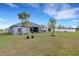 Large backyard with a covered patio, mature trees, and ample space for recreation at 2572 Averland Loop, North Port, FL 34287