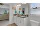 Bright bathroom featuring double sinks, granite countertops, modern fixtures, and view to another bedroom at 2572 Averland Loop, North Port, FL 34287