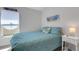 Bedroom with a cozy bed, beach-themed artwork, and a well-lit window offering a peaceful ambiance at 2572 Averland Loop, North Port, FL 34287