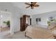 Bright bedroom features a ceiling fan, stylish wood armoire and an inviting view of a plant-filled hallway at 2572 Averland Loop, North Port, FL 34287