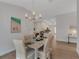 Dining room with seating for six, a modern chandelier, and views of the open concept kitchen at 2572 Averland Loop, North Port, FL 34287