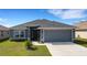 Charming single-story home showcasing a well-manicured lawn and a gray color scheme at 2572 Averland Loop, North Port, FL 34287