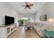 Bright living room featuring a comfortable sectional sofa and wood-look tile flooring at 2572 Averland Loop, North Port, FL 34287