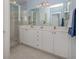 Bathroom featuring double sinks, a large mirror, and a glass-enclosed shower at 2602 Ravinia Cir # 2602, Venice, FL 34292