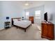 Bright bedroom with a wooden bed frame, two windows and simple decor at 2602 Ravinia Cir # 2602, Venice, FL 34292