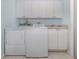Laundry room with a washer, dryer, sink, and overhead cabinets for storage at 2602 Ravinia Cir # 2602, Venice, FL 34292