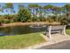 Beautiful pond with fountain, bench, and lush greenery at 2602 Ravinia Cir # 2602, Venice, FL 34292