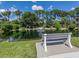 Picturesque pond with a fountain surrounded by lush greenery, trees and a bench at 2602 Ravinia Cir # 2602, Venice, FL 34292