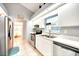 Modern kitchen features white cabinets, stainless steel appliances, tile flooring, and an adjoining bath at 2783 Biscayne Dr, North Port, FL 34287