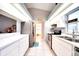 Modern galley kitchen features white cabinets, stainless steel appliances, bright lighting, and vaulted ceiling at 2783 Biscayne Dr, North Port, FL 34287