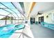 Relaxing screened-in pool area with patio seating, a ceiling fan, and views of the shimmering pool and spa at 2783 Biscayne Dr, North Port, FL 34287