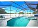 Screened pool area with a crystal blue pool, hot tub and a calming blue sky above at 2783 Biscayne Dr, North Port, FL 34287