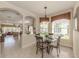 Cozy dining area with a glass table, decorative chandelier, and views into the living room at 29692 Niagara Ct, Englewood, FL 34223