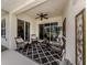 Inviting lanai featuring stylish outdoor seating, a ceiling fan, and scenic backyard views at 29692 Niagara Ct, Englewood, FL 34223