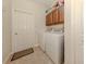Bright laundry room with modern washer and dryer set, built in cabinetry, and easy access to the exterior at 29692 Niagara Ct, Englewood, FL 34223