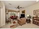 Cozy living room with neutral walls, ceiling fan, and a large window for natural light at 29692 Niagara Ct, Englewood, FL 34223