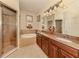 Elegant main bathroom featuring a soaking tub, separate shower, and dual sinks at 29692 Niagara Ct, Englewood, FL 34223