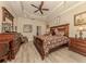 Spacious main bedroom with a large bed, tray ceiling, and elegant wood furniture at 29692 Niagara Ct, Englewood, FL 34223