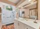 Modern bathroom featuring white cabinetry, a tiled shower, and a large framed vanity mirror at 311 Pembroke Dr # 217, Venice, FL 34293