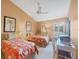 Bright bedroom featuring twin beds, a ceiling fan, and ample natural light from the window at 311 Pembroke Dr # 217, Venice, FL 34293