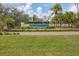 Community entrance sign amidst a lush green lawn with manicured bushes and palm trees at 311 Pembroke Dr # 217, Venice, FL 34293