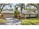 Single-story home featuring a neutral color palette, tile roof, attached garage, and mature landscaping at 311 Pembroke Dr # 217, Venice, FL 34293