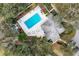 Overhead shot of a shared community pool with lounge chairs and tables set amidst the beauty of tropical trees at 311 Pembroke Dr # 217, Venice, FL 34293