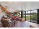 Spacious sunroom featuring comfortable seating arrangements and a serene view of the tranquil lake at 311 Pembroke Dr # 217, Venice, FL 34293