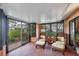Relaxing sunroom with comfortable wicker seating and private garden views through large windows at 311 Pembroke Dr # 217, Venice, FL 34293