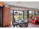 Bright sunroom dining area with a glass table and seating for four offers pretty lake views at 311 Pembroke Dr # 217, Venice, FL 34293