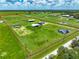 Lush property featuring a house, outbuildings and a defined boundary, with green fields, ponds and mature trees at 35960 State Road 70 E, Myakka City, FL 34251