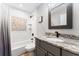 Bathroom features a shower-tub combo with subway tile and decorative marble vanity at 35960 State Road 70 E, Myakka City, FL 34251