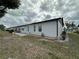 Spacious backyard featuring well-maintained lawn, gravel landscaping and mature trees at 404 Elder St # 230, Englewood, FL 34223