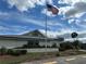 Well maintained clubhouse exterior with flag pole and neatly kept landscaping in a retirement community at 404 Elder St # 230, Englewood, FL 34223
