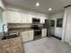 Well-lit kitchen with stainless steel appliances, granite counters, and ample cabinet space at 404 Elder St # 230, Englewood, FL 34223