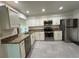 Bright kitchen featuring stainless steel appliances, white cabinets, granite counters and tile floor at 404 Elder St # 230, Englewood, FL 34223